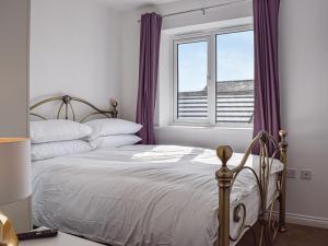 a bedroom with a bed and a window with purple curtains at The Goldsmith in Blackpool