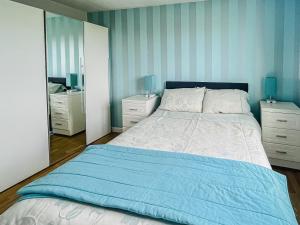 a bedroom with a bed and two dressers and a mirror at Gramsdale House in Gramisdale