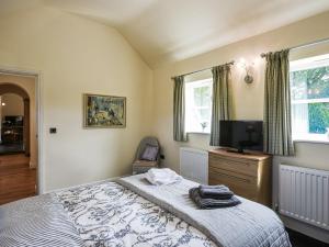 um quarto com uma cama e uma televisão de ecrã plano em Orchard View em Minsterley