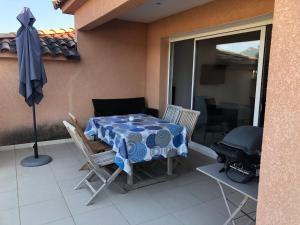 a patio with a table and chairs and a grill at punta di buturetu in Propriano