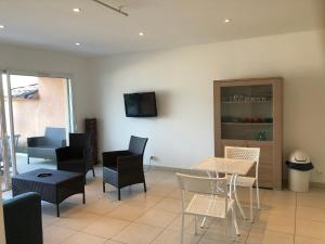a living room with chairs and a table and a tv at punta di buturetu in Propriano