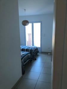 two beds in a room with a window at punta di buturetu in Propriano