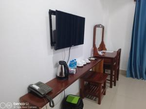 a room with a telephone and a television on a wall at Lisha The Grand Riverside Hotel in Vang Vieng