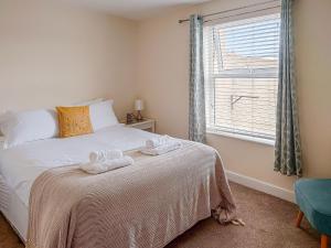 a bedroom with a bed with two towels on it at Oakleigh By The Sea in Cromer