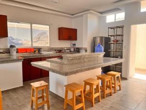 a kitchen with a counter and some wooden stools at Casa Halley #4 con vista al mar y piscina , 2 pisos - Villamil Playas , Data de Villamil in Playas