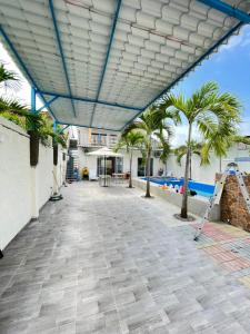 a patio with palm trees and a building at Casa Halley #4 con vista al mar y piscina , 2 pisos - Villamil Playas , Data de Villamil in Playas