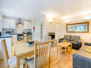 a kitchen and living room with a table and a couch at Burnside West Cottage- Uk39596 in Strathkinness