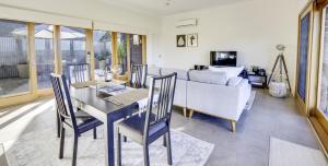 - un salon avec une table, des chaises et un canapé dans l'établissement Seascape Retreat, à Victor Harbor