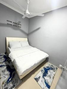 Habitación blanca con cama y ventilador de techo. en Baiduri Homestay, en Kota Tinggi