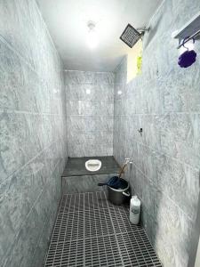 a tiled bathroom with a toilet and a sink at Baiduri Homestay in Kota Tinggi +3 photos