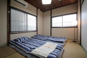 Postel nebo postele na pokoji v ubytování 2F SAKURA RIVER HOUSE, yao 桜と川の家 2F