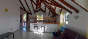 eine Küche und ein Wohnzimmer mit einem Sofa und einer Theke in der Unterkunft HAUT DE VILLA VU SUR LA MONTAGNE. in Saint-Louis