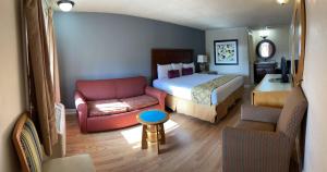 une chambre d'hôtel avec un lit et un canapé dans l'établissement LIBERTY INN, à Kissimmee