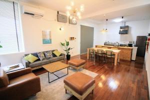 a living room with a couch and a table at Guest room MINAMI 沖縄 in Okinawa City