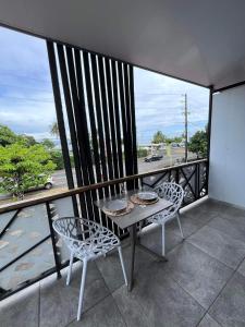 普納奧亞的住宿－2 accomodations -Studio du Manoir -Le Manoir，阳台配有桌椅,享有街道的景色。