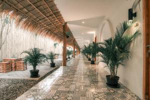 Demoska Villa Jogja With Privatepool في Kejayan: ممر مع نباتات الفخار في مبنى