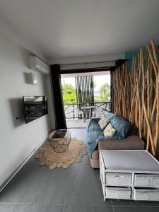 ein Wohnzimmer mit einem Sofa und einem Tisch in der Unterkunft 2 accomodations -Studio du Manoir -Le Manoir in Punaauia
