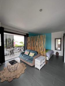 ein Wohnzimmer mit einem Sofa und einem Tisch in der Unterkunft 2 accomodations -Studio du Manoir -Le Manoir in Punaauia