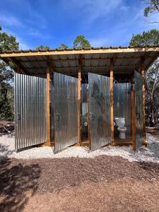 servizi igienici sotto una struttura in legno con servizi igienici interni di The Juniper Ranch and Retreat a Canyon Lake