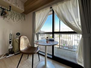a table and a chair in a room with a window at 【New】Hokusei 52 in Kita-rokujō