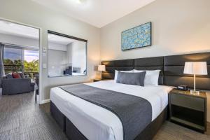 una camera d'albergo con un grande letto e una finestra di Hudson Berrimah a Darwin