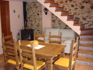 a dining room with a wooden table and chairs at La Serreta in Paúls