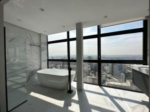 a bathroom with a tub and a large window at Sky Loft - Andar 41 in Sao Paulo