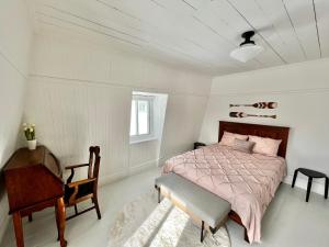 1 dormitorio con cama, escritorio y silla en Auberge musicale Pour un Instant, en La Malbaie