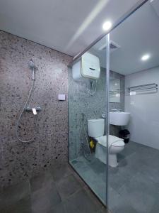 a bathroom with a shower and a toilet at Country Heritage Hotel in Surabaya
