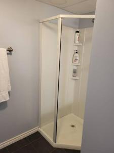 a shower with a glass door in a bathroom at Private basement apartment in Saskatoon