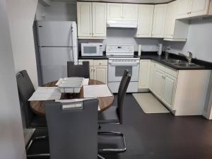 a kitchen with a wooden table and white appliances at Private basement apartment in Saskatoon