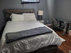 a bedroom with a bed with a desk and a desk at Private basement apartment in Saskatoon
