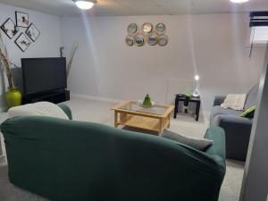 a living room with a green couch and a table at Private basement apartment in Saskatoon