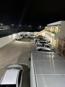 a row of cars parked in a parking lot at night at Pousada vista alegre in Itaberaba