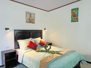1 dormitorio con 1 cama grande con almohadas rojas en Monteverde Magic Mountain, en Monteverde