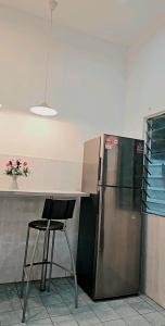 a kitchen with a refrigerator and a table and a chair at Soul Casa @Gurney Heights Keramat in Kuala Lumpur
