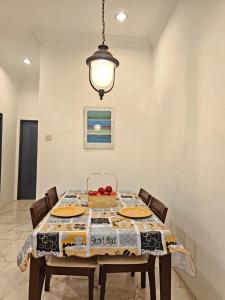 a dining room with a table and a light fixture at Soul Casa @Gurney Heights Keramat in Kuala Lumpur