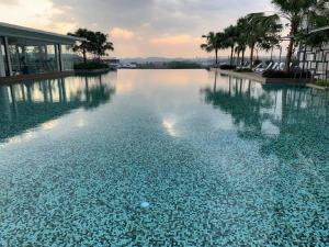 a large pool of water with palm trees and a building at D'Hive By Tiara Imperio in Kajang