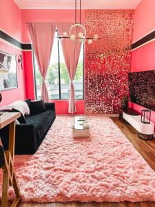 uma sala de estar cor-de-rosa com um sofá preto e um tapete rosa em Dolly's Glam Getaway - Glittering Gem Near Broadway em Nashville