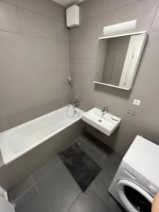 a bathroom with a sink and a bath tub and a mirror at FREE 2X parking and free Wifi NEW Suncatcher apartment in Bratislava