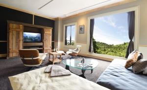 a living room with a couch and a large window at Shelter Garden Nikko in Nikko