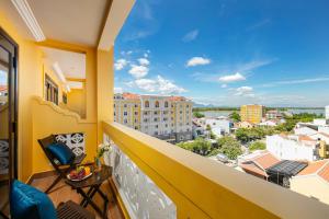 a balcony with a view of a city at La Charm Hoi An Hotel & Spa in Hoi An