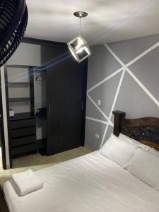 1 dormitorio con 1 cama blanca grande y techo en Apartamento en Bucaramanga en Bucaramanga