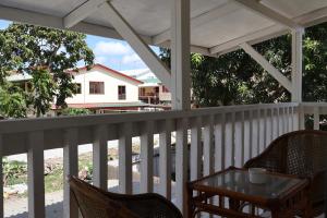 um alpendre com mesa e cadeiras e uma casa em 'Ataongo Residence em Nuku‘alofa