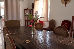 uma mesa de madeira com um vaso de flores em 'Ataongo Residence em Nuku‘alofa