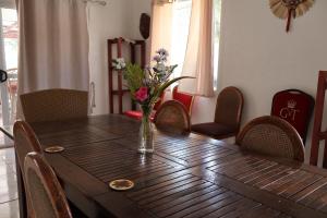 a wooden table with a vase of flowers on it at 'Ataongo Residence in Nuku‘alofa