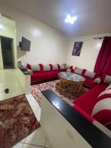 een woonkamer met een rode bank en een tafel bij اقامة طريق الخير in Agadir