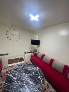 een woonkamer met een bank en een klok aan de muur bij اقامة طريق الخير in Agadir