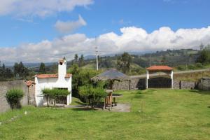 a garden with a table and a gazebo at Rumipaxi Lodge in Latacunga