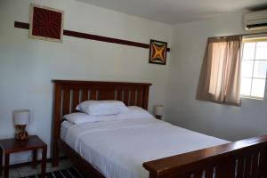 um quarto com uma cama e uma janela em 'Ataongo Residence em Nuku‘alofa